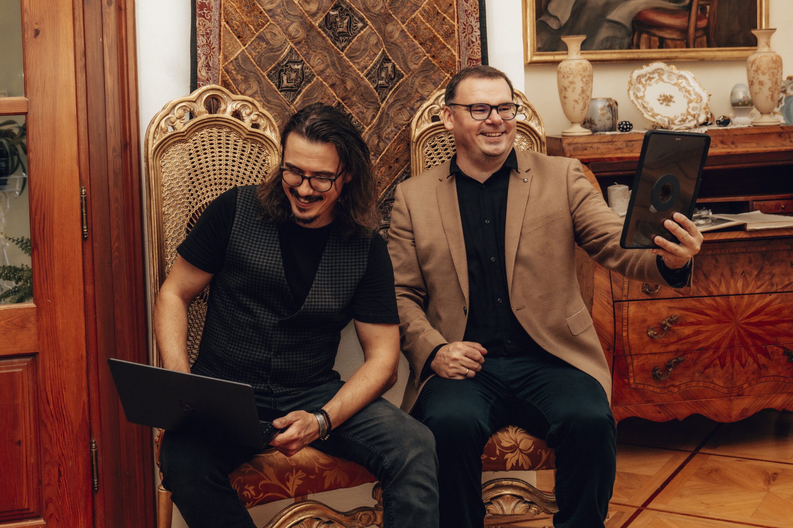Uśmiechnięci specjaliści z laptopem i tabletem, czyli sztuka reklamy